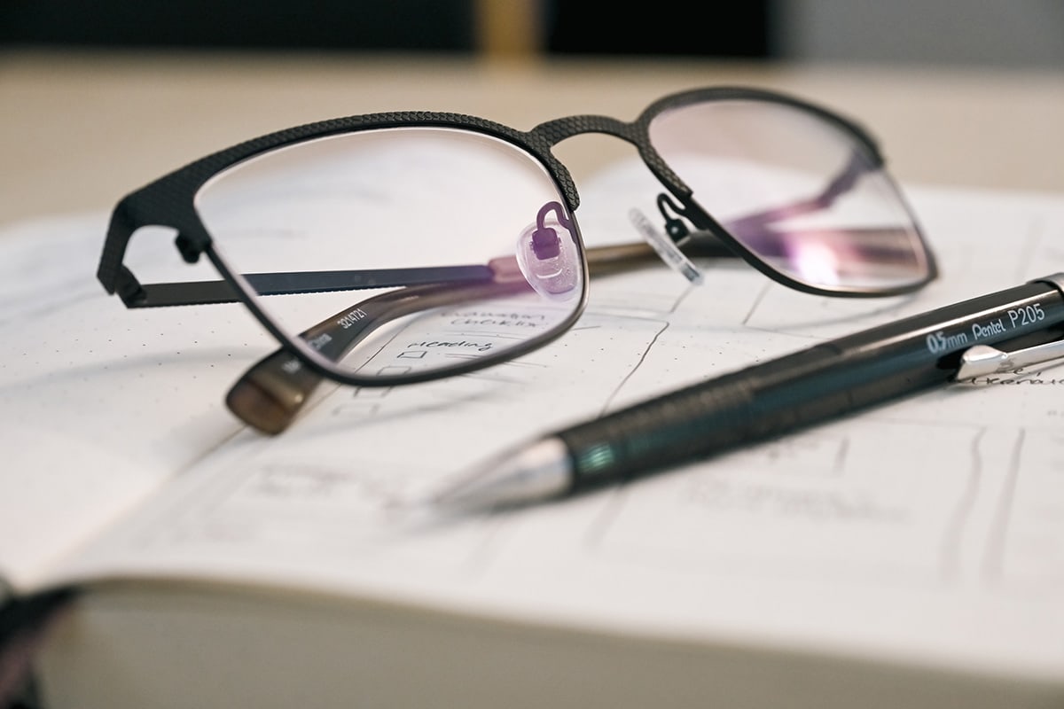 Eyeglasses and pencil sitting on top of open sketchbook • Photo by Mary-Ann Zykin