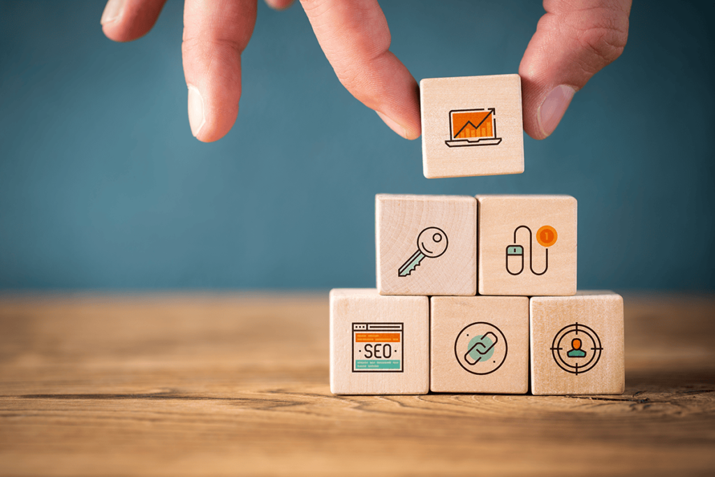 Hands placing blocks with SEO and marketing icons on the side