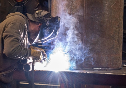 Construction worker welding metal pipes • Photo by Mary-Ann Zykin