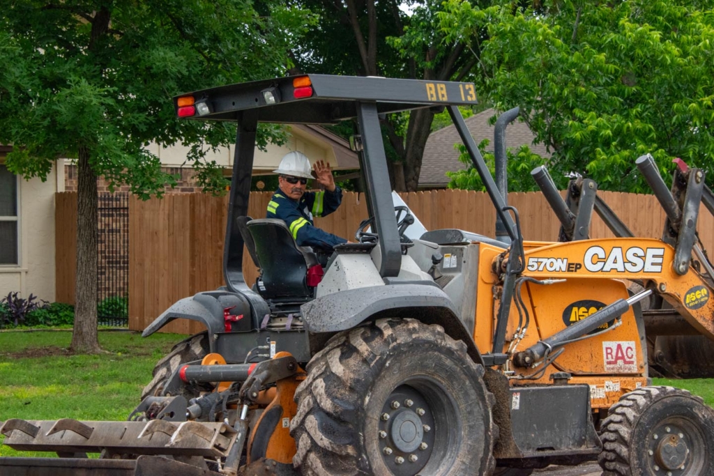 Construction worker driving tractor loader • Photo by Mary-Ann Zykin