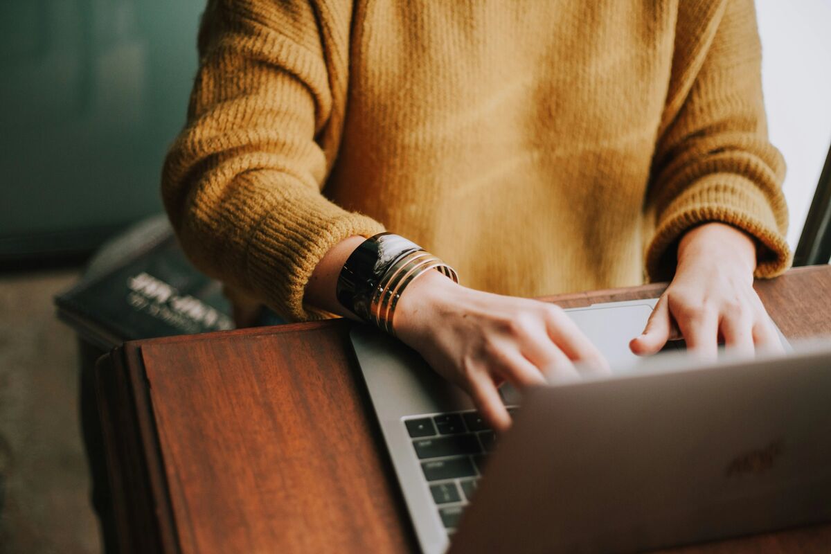 Hands typing on a laptop.