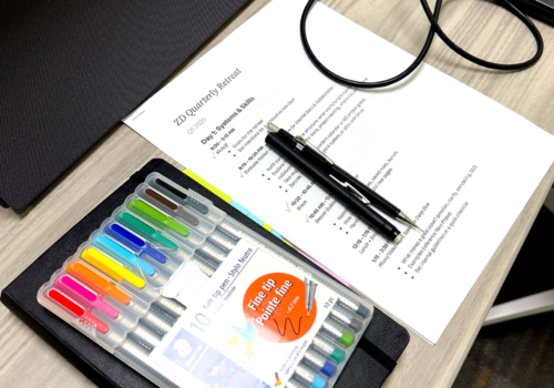 Pens and the retreat agenda on a desk