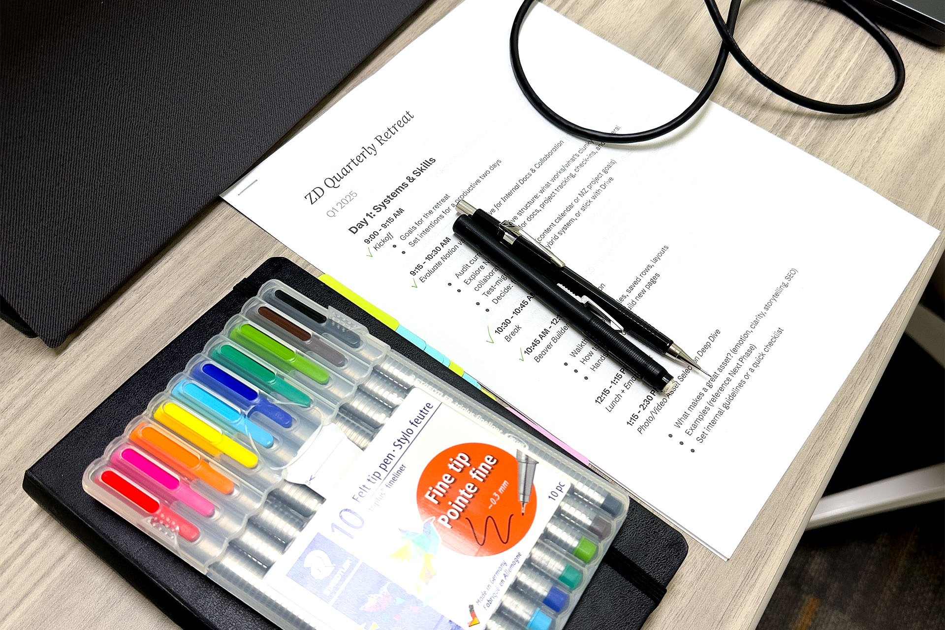 Pens and the retreat agenda on a desk