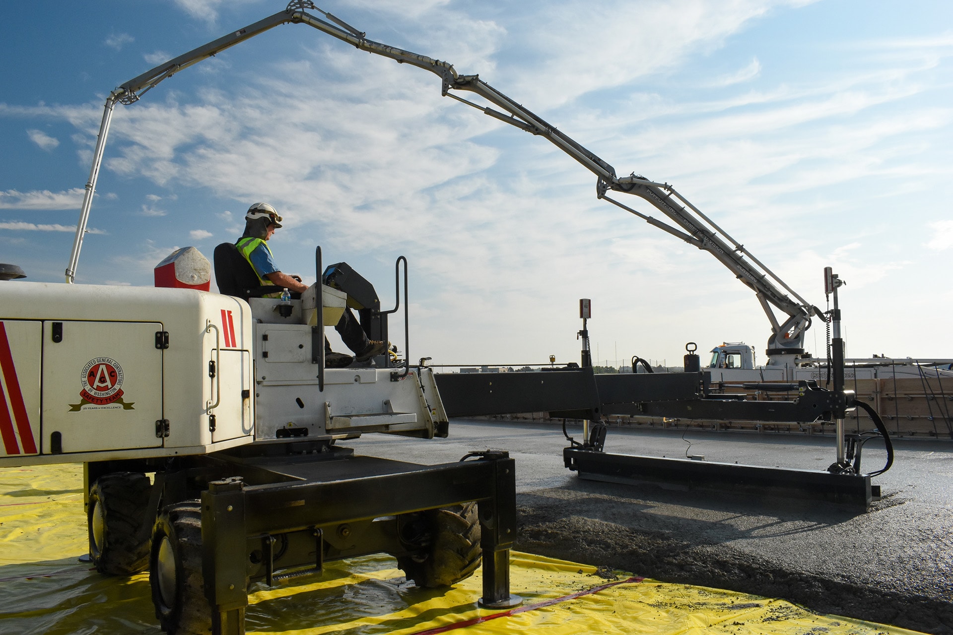 Laser screed smoothing freshly poured concrete during a school construction project