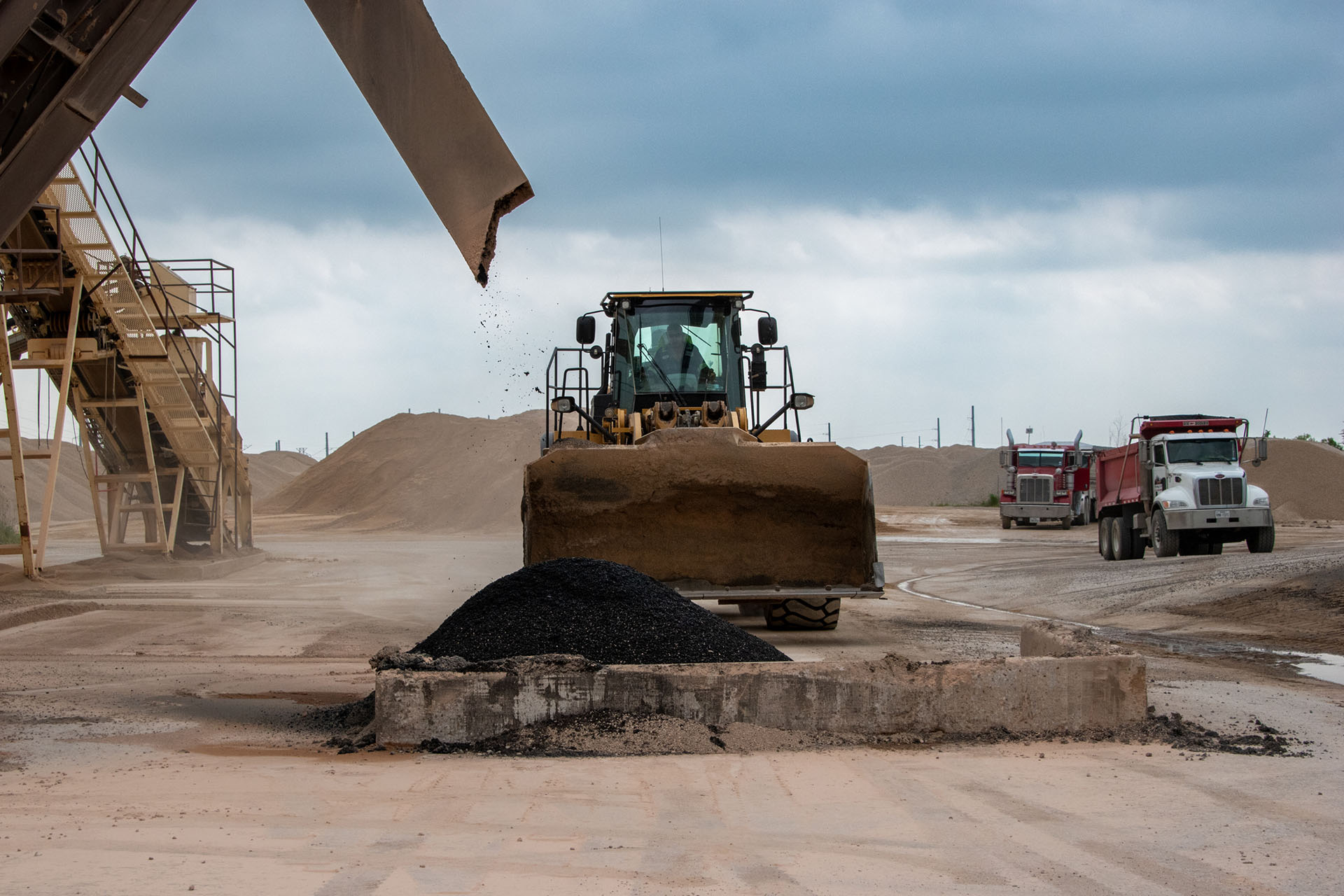 Asphalt being poured with a bulldozer in the background