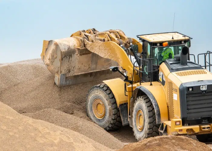 Loader dumping a pile of aggregate at an asphalt plant