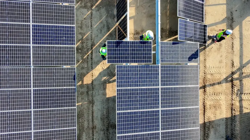 Overhead view of three workers installing solar panels.