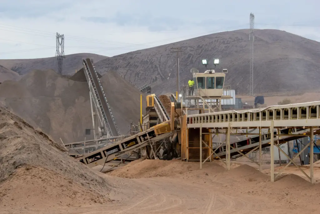 Industrial scene with machinery and dirt piles.
