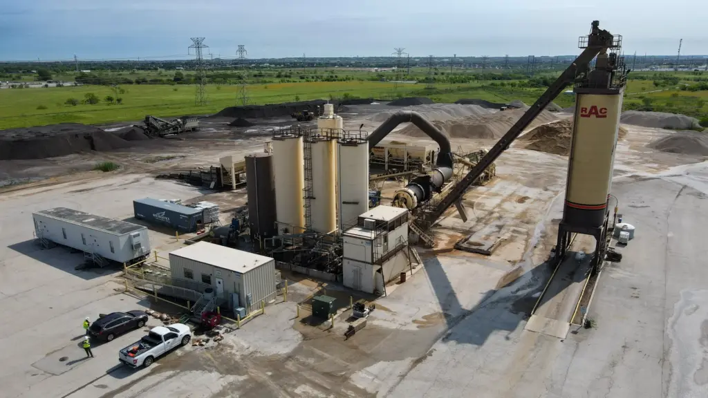 An aerial view of an asphalt plant with vehicles and machinery.