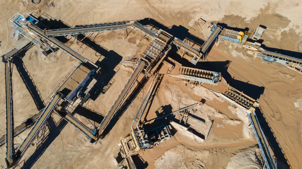 An aerial view of a construction site with various crushing structures and aggregate machinery.