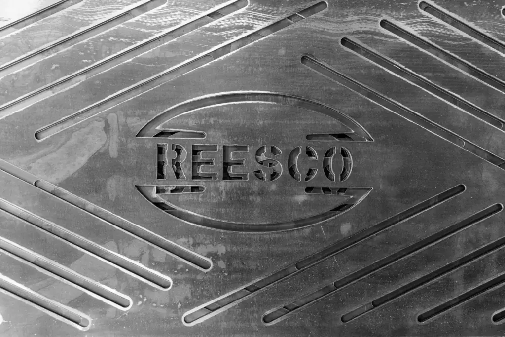 The word "REESCO" is embossed on a textured surface with diagonal lines and curves.